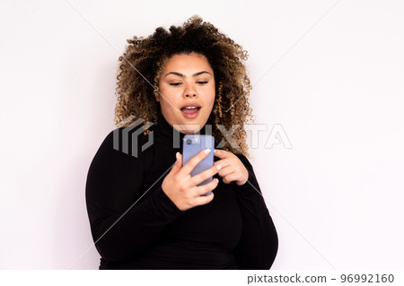 Surprised young woman looking at smartphone 96992160