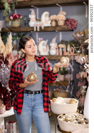 Woman choosing christmas tree decorations Woman choosing christmas tree decorations 96992837