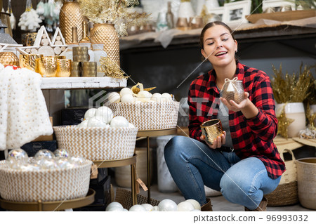 Happy woman in a gift shop choosing Christmas present 96993032