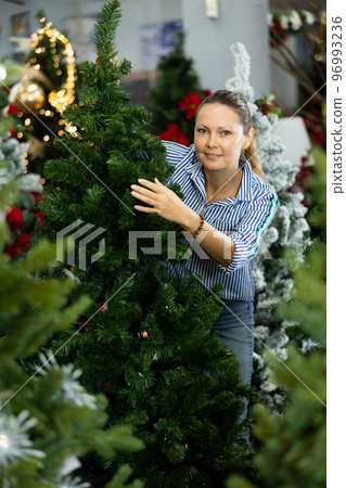 Female buying artificial tree at Christmas Fair 96993236