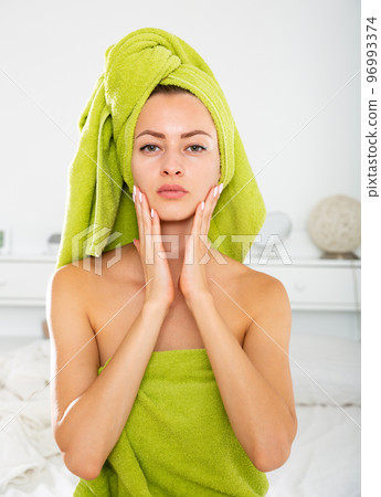 Girl in towel doing facial massage Girl in towel doing facial massage 96993374