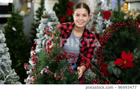 Portrait of positive girl at christmas tree in market Portrait of positive girl at christmas tree in market 96993477