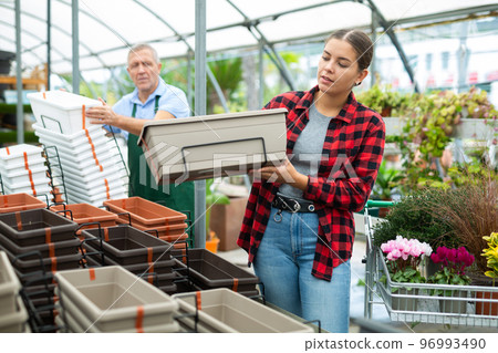 Woman buying plastic flower containers at flower market Woman buying plastic flower containers at flower market 96993490