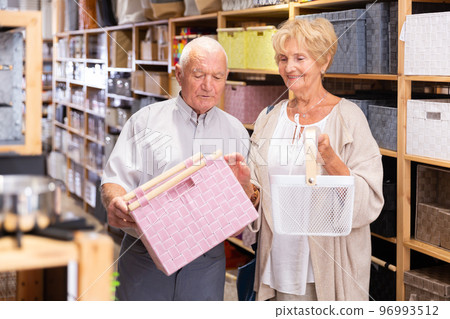Mature married couple makes choice of buying a basket for country house Mature married couple makes choice of buying a basket for country house 96993512