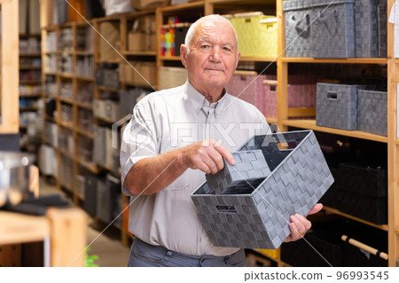 Senior man choosing storage basket at shop 96993545