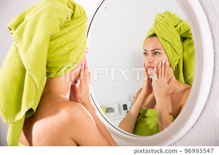 Female looking in mirror at home 96993547