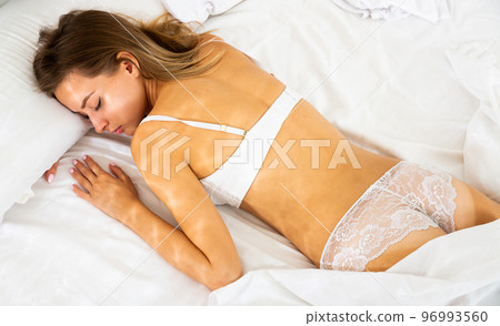 Pretty girl sleeping deeply in bed in morning Pretty girl sleeping deeply in bed in morning 96993560