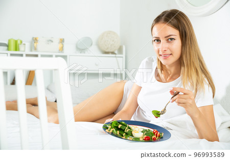 Girl having healthy breakfast in bed 96993589