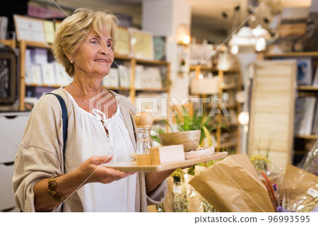 Active senior woman shopping at household store 96993595