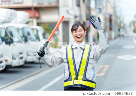 Female security guard directing traffic 96994658