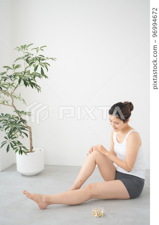 A woman doing moxibustion on her leg A woman doing moxibustion on her leg 96994672