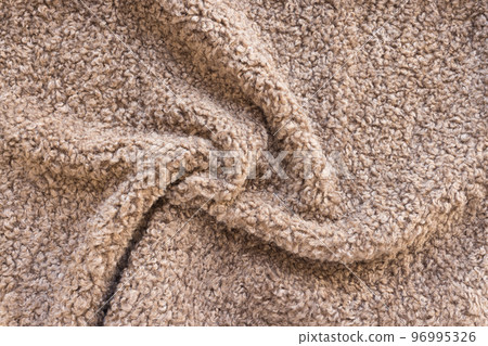 New soft brown curly teddy fleece plush throw blanket or pillow case. Abstract fabric texture background with curles. Top view, closeup 96995326