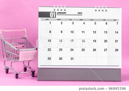 The January 2023 desk calendar with shopping cart against pink background. The January 2023 desk calendar with shopping cart against pink background. 96995396