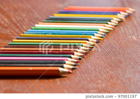 A lot of colored pencils in the warm sunlight 97001197