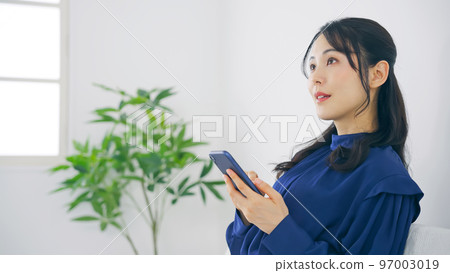 一個在室內使用智能手機的女人 97003019