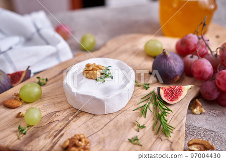 Camembert or brie cheese on wooden cutting board at domestic kitchen 97004430