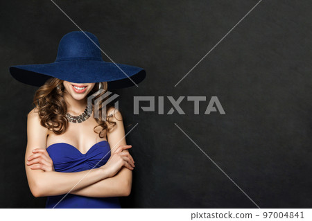Fashion Portrait of Smiling Woman in Blue Dress and wide blue hat, Girl with Curly Hair 97004841