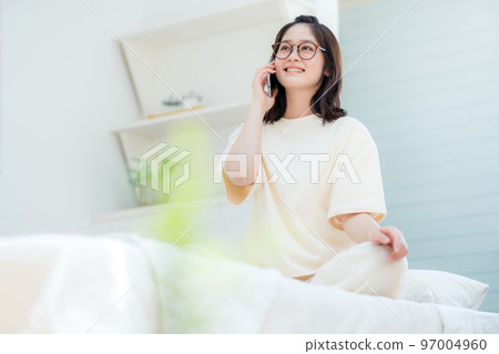 Young woman talking in bedroom Young woman talking in bedroom 97004960