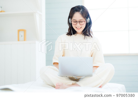Young woman watching videos on laptop 97005380