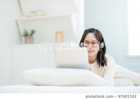 Young woman watching videos on laptop 97005382
