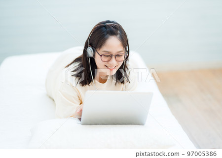 Young woman watching videos on laptop 97005386