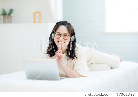 Young woman watching videos on laptop 97005388