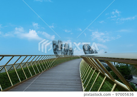 Landscape view of the Golden Bridge is lifted by two giant hands on Ba Na Hill, Da Nang, Vietnam. 97005636