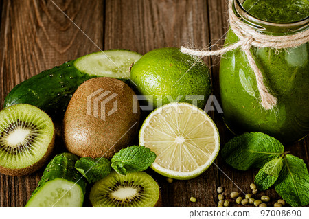 Blended green smoothie with ingredients on the wooden table. Green cocktail. Healthy food  97008690