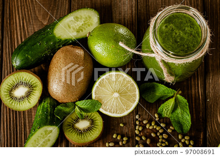 Top view of blended green smoothie with ingredients on the wooden table. Healthy food concept  97008691
