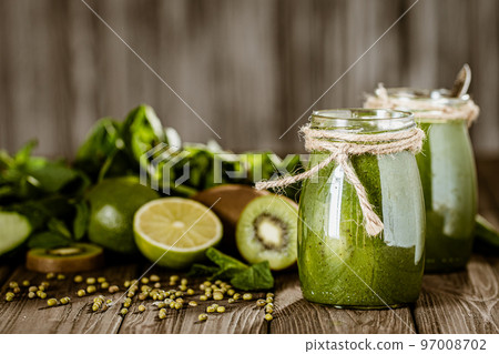 Blended green smoothie with ingredients on the wooden table. Green cocktail. Healthy food  97008702