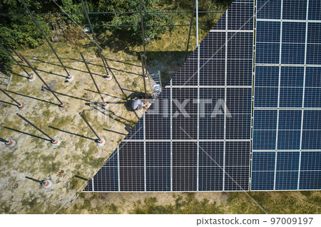 Photovoltaic solar panel fading away and shifting into metal supporting structure. Transition between solar module and metal poles in grassy field. Before and after concept. 97009197