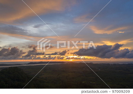 aerial view beautiful yellow sunrise above the mountain in phang Nga valley. slow floating fog blowing cover on the mountain look like as a sea of mist. scenery golden sunrise at horizon background. aerial view beautiful yellow sunrise above the mountain in phang Nga valley. slow floating fog blowing cover on the mountain look like as a sea of mist. scenery golden sunrise at horizon background. 97009209