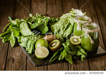 Blended green smoothie with ingredients on the wooden table. Green cocktail. Healthy food  97009589