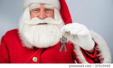 Santa Claus holds keys on a white background. New home gift for christmas. Santa Claus holds keys on a white background. New home gift for christmas. 97010489