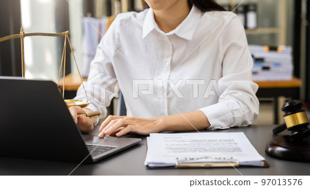 Justice and law concept. Female judge in office with the gavel working with digital tablet computer docking keyboard. Justice and law concept. Female judge in office with the gavel working with digital tablet computer docking keyboard. 97013576