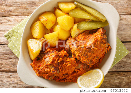 African and Portuguese cuisine galinha a Africana or frango assado is a dish traditionally associated with Macau close up on the pot. Horizontal top view 97013932