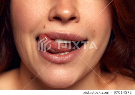 Close-up view of female perfect shape mouth with nude colored lipstick. Moisturizing. Sexy, sensual lips Close-up view of female perfect shape mouth with nude colored lipstick. Moisturizing. Sexy, sensual lips 97014572