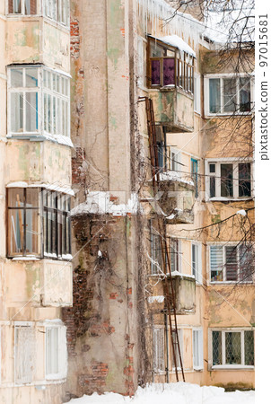 An old four-story house with glazed balconies, a stone chimney on the wall. An old four-story house with glazed balconies, a stone chimney on the wall. 97015681