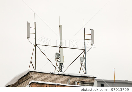 Several cellular antennas on the roof of the house provide communication. Several cellular antennas on the roof of the house provide communication. 97015709
