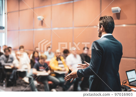 Speaker at Business Conference with Public Presentations. Audience at the conference hall. Entrepreneurship club. Rear view. Horisontal composition. Background blur. 97016903
