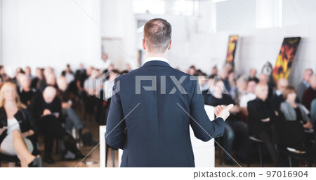 Speaker at Business Conference with Public Presentations. Audience at the conference hall. Entrepreneurship club. Rear view. Horisontal composition. Background blur. 97016904