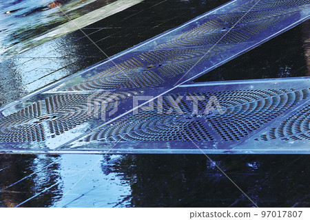 Wet tiled pavement floor with sewer metal gratings for water drainage 97017807