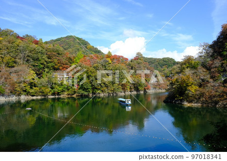 A sightseeing boat that runs through Taishakukyo Gorge and Lake Shinryu in autumn colors 97018341