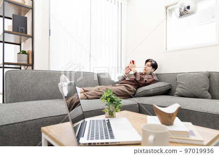 遠程辦公一個男人休息並使用智能手機 遠程辦公一個男人休息並使用智能手機 97019936
