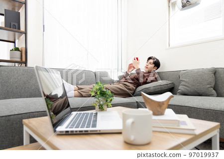 遠程辦公一個男人休息並使用智能手機 遠程辦公一個男人休息並使用智能手機 97019937
