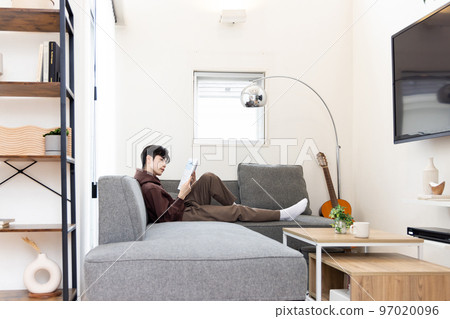 College student sitting on the sofa and studying College student sitting on the sofa and studying 97020096