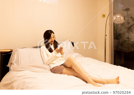 在臥室床上使用智能手機的女人 97020284