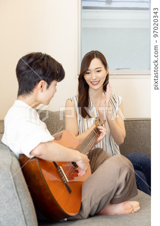 Home time A couple enjoying the guitar Home time A couple enjoying the guitar 97020343