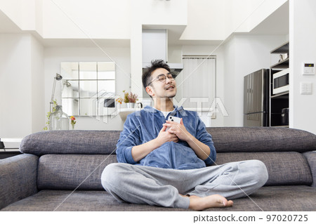 一個男人在沙發上使用智能手機 一個男人在沙發上使用智能手機 97020725