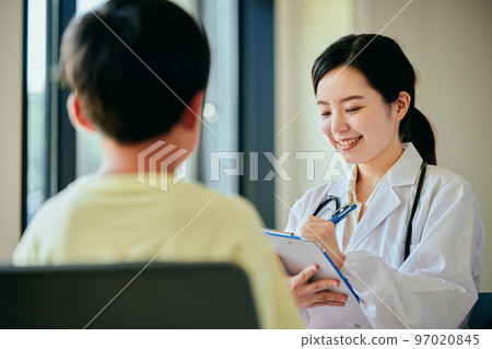 檢查一個小學男孩的年輕女性醫生 97020845